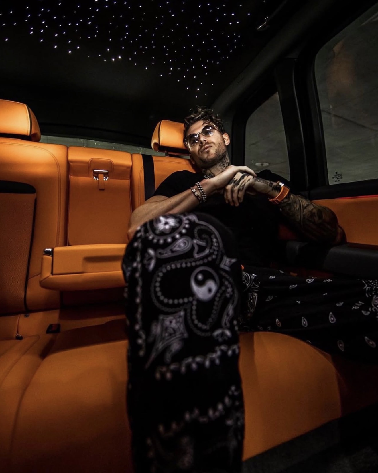 Branden Condy seated in the orange leather interior of a Rolls-Royce Cullinan at night